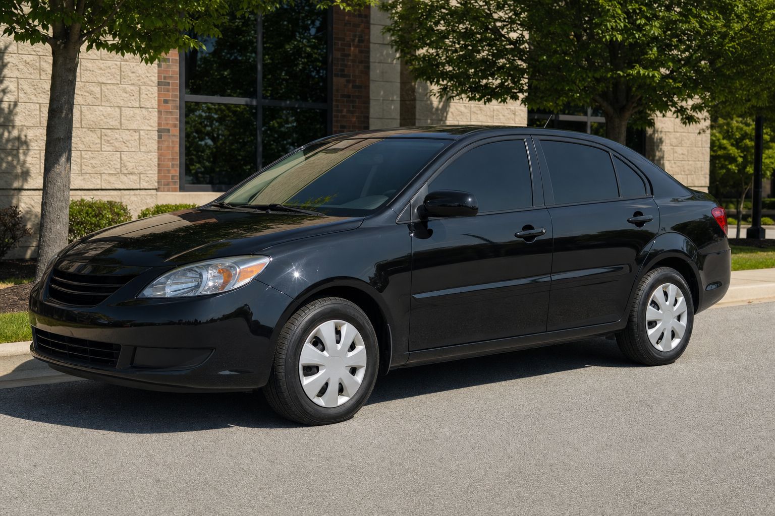 Black everyday sedan with a clean, neutral dark window tint look in summer daylight.