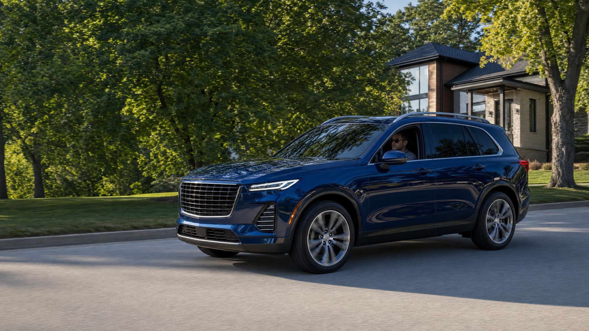 Blue premium SUV in motion on a tree-lined residential street.